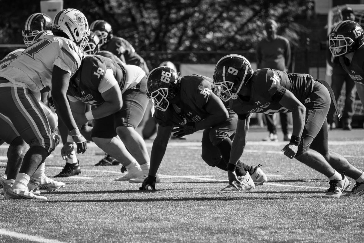 TIGERS ON DEFENSE - The Tigers at the line of scrimmage against the Roosevelt
RuffRiders. Pictured: #9 junior Cam Butler and #66 senior Chi Osuchukwu.