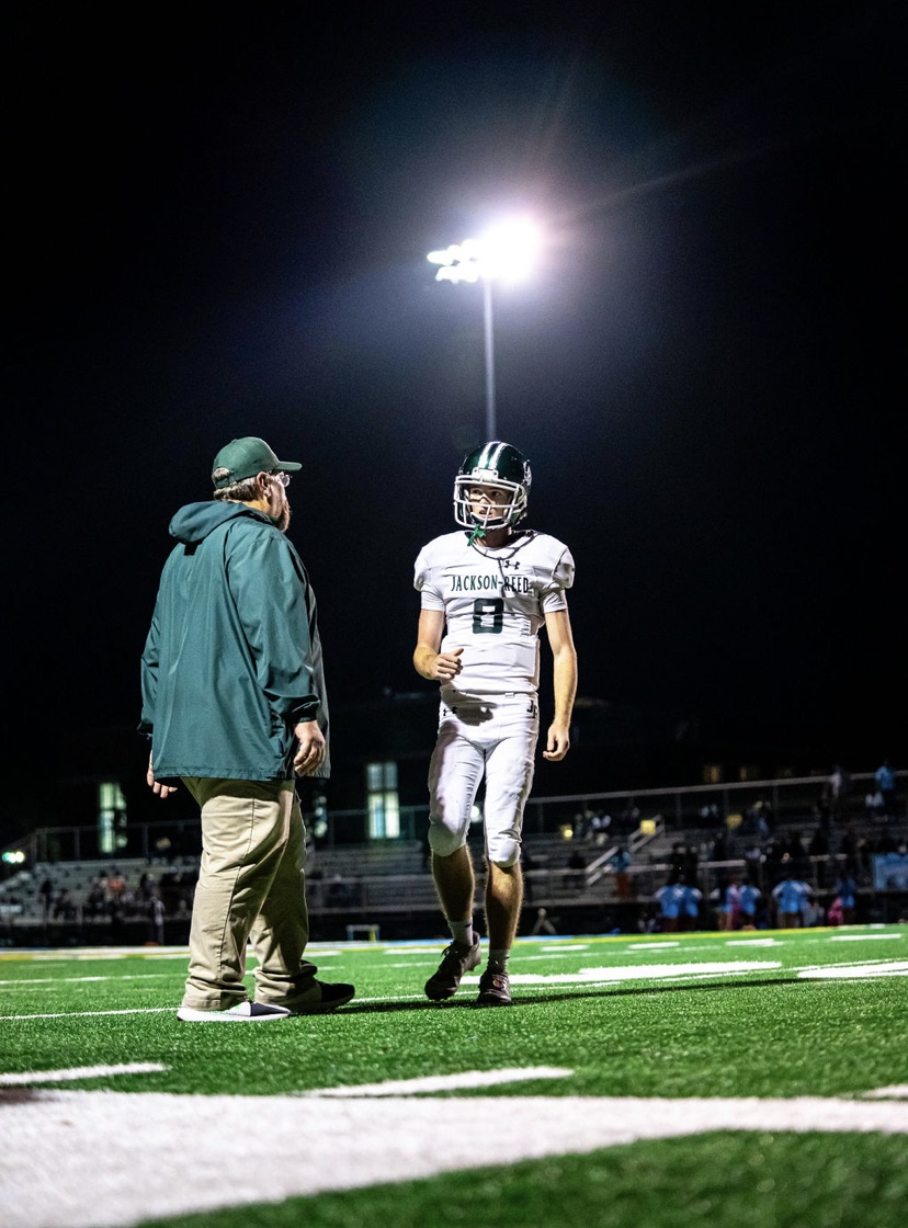 JR Varsity football offensive coordinator Mark Mullen and senior quarterback Ward Dieterle during a timeout against Eastern Senior High School. 