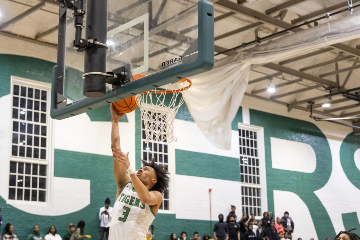 EASY LAY - Senior Lucas Sekasi goes for a layup in the Den. The team has had a roaring season, acquiring the title of #21 in the nation.