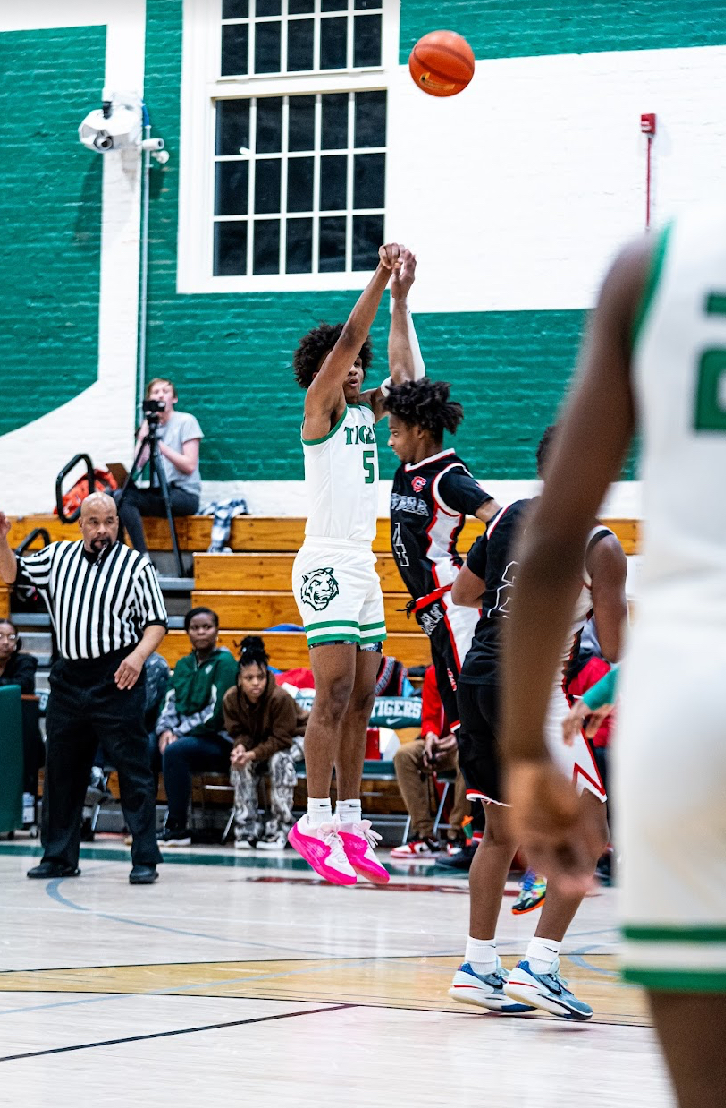 SPOT UP: Senior small forward Scottie Hubbard attempting a three pointer against Dunbar from Feb. 15. 