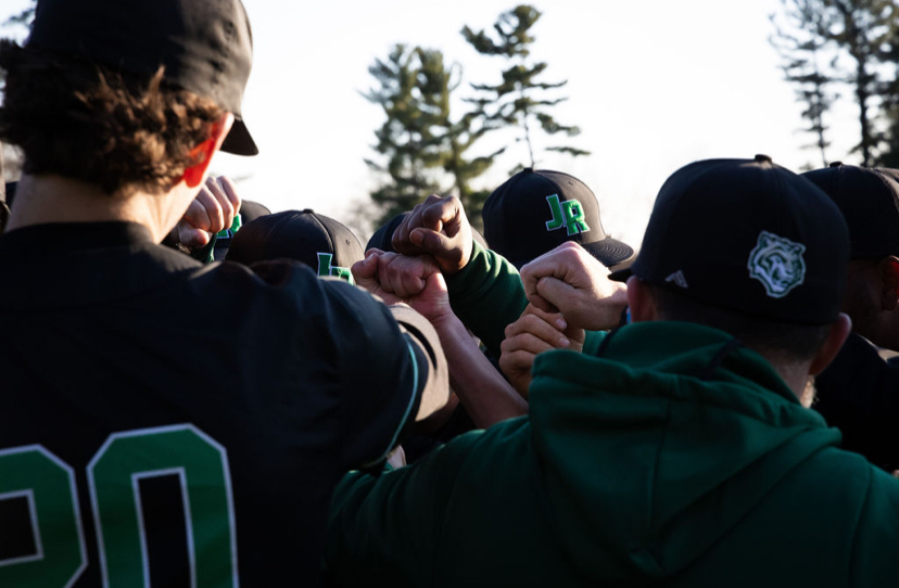 ONE TEAM - The varsity baseball embrace after a March 21 win over the Landon School. Nearly two months later, the goal of a DCSAA title is near. 