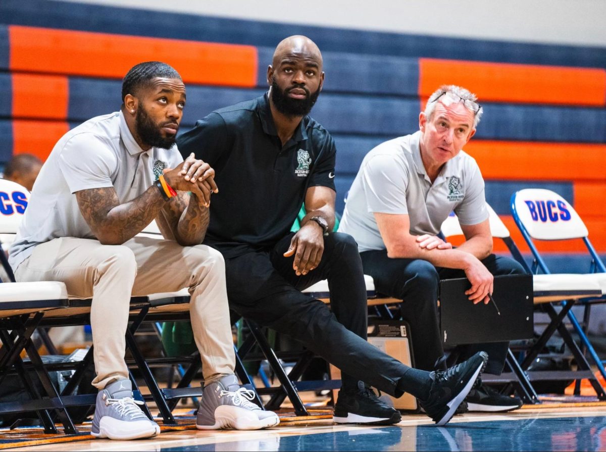 COACHES DEBRIEF: Head coach David “Tee” Johnson, Bill Bourgouin and Anifantis having a conversation on the sideline benches during the 2023 winter season. 

Pictured L to R: Johnson, Bourgouin, Anifantis. 