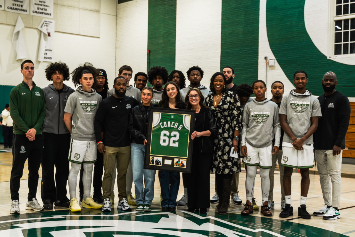 TIGER FAMILY: The varsity basketball team and the Anifantis family pose for a picture at center court pregame to celebrate Coach G night. 